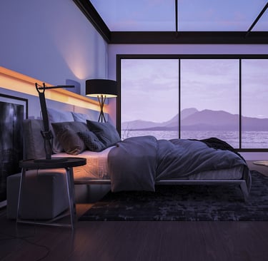Modern bedroom with large bed, floor-to-ceiling windows, and view of lake and mountains.