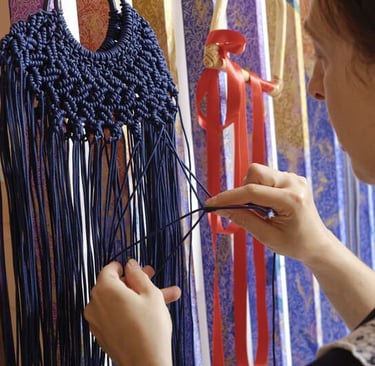 chica tejiendo un macrame de hilo azul