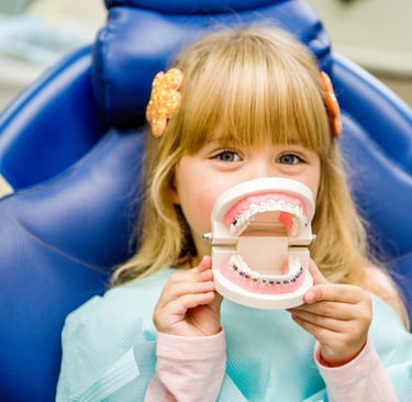 a little girl sitting in a chair with a toothbrush
