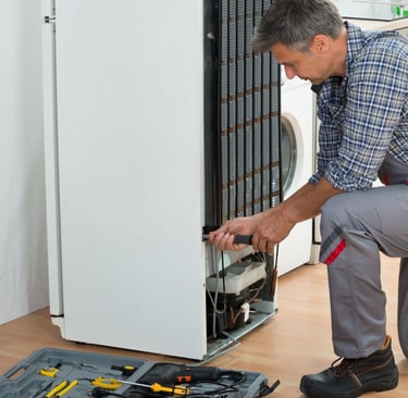 a man in a plaid shirt and pants is fixing a dishwasher