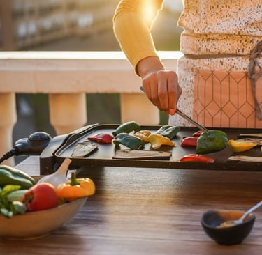 a woman in a white apron is cooking on a grill