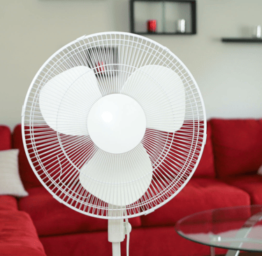 a red couch and a table with a fan