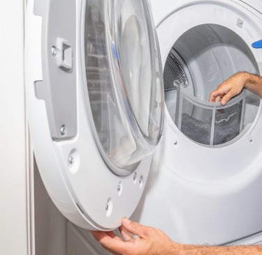 a man in a blue shirt is looking at a washing machine
