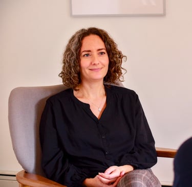 Female therapist with a relaxed and calm demeanor sits across from client 