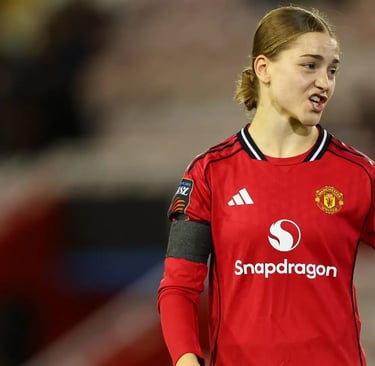 a woman in a red jersey shirt is holding a soccer ball