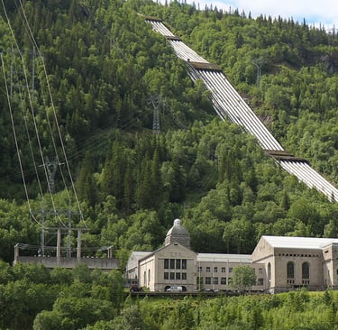 A large industrial building sits at the base of a green slope-NIA used with permission