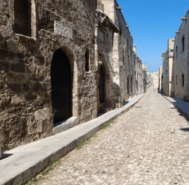 a narrow cobblestone street with a stone path in streets of knights in rhodes old town