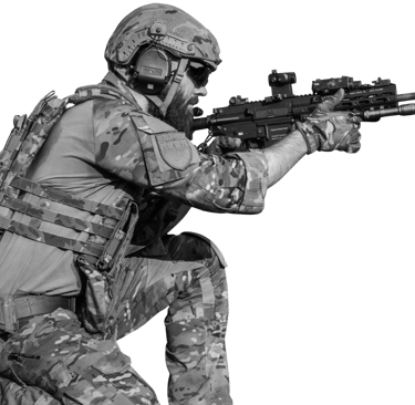 Profesionalus airsofto žaidėjas su pilna taktine ekipuote klūpi ir taikosi su moderniu šratasvydžio