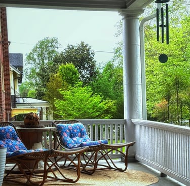 Front porch with lounger chairs and wind chimes 2123 Rivermont apartments