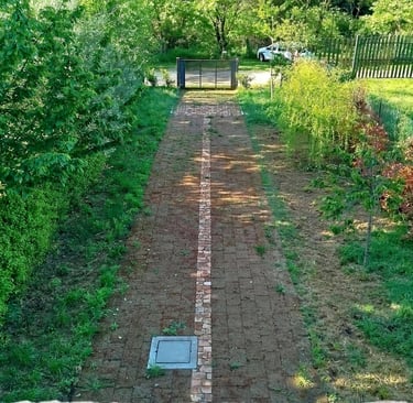Giardino privato in vendita con vialetto pavimentato e accesso carrabile.