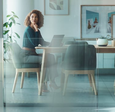 a woman sitting at a table with a laptop