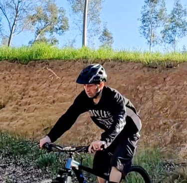 mountain biker riding out of a steep roll in