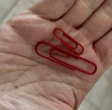 two red paper clips held in hand