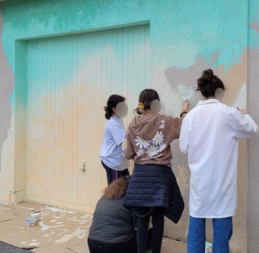 Des élèves peigent une fresque sur le mur d'une cour d'école