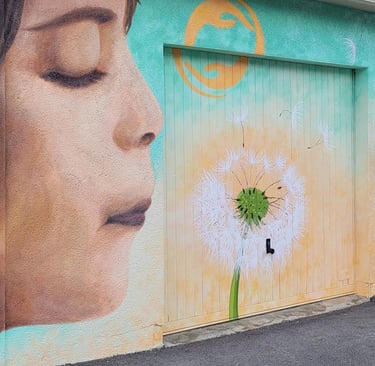 Fresque extérieure peinte, représentant un enfant souflant sur un pissenlit.