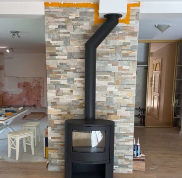 Installation de poêle à bois moderne avec mur en pierre naturelle