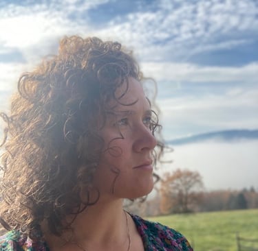 Portrait d'une Architecte d'interieur avec des cheveux frisée et un regard bleu lointain 