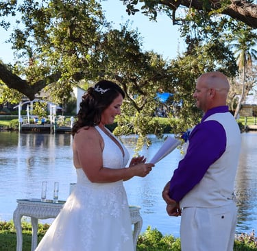 a bride and groom standing in front of a lake