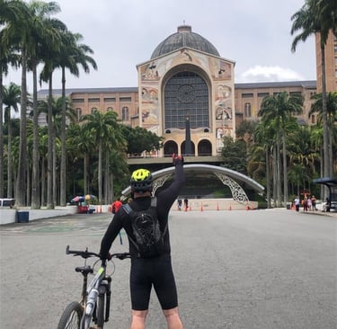 Ciclista de frente para a fachada do Santuário Nacional de Aparecida