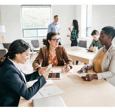 3 women talking over workdesk
