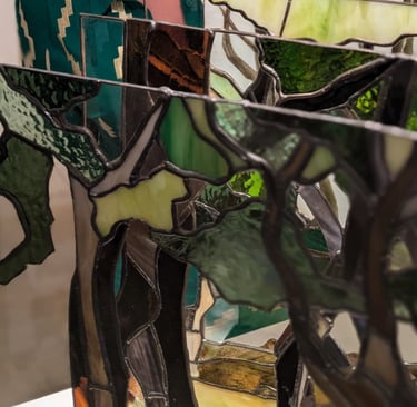 Image of Artist Laura Kriefman at Biennale Exhibition opening. Laura is smiling and looking at  her bespoke glass art