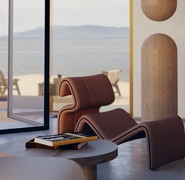 Close-up of a sculptural lounge chair beside a round wooden table in a serene, ocean-facing interior