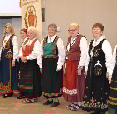 one man and eight women in bunad