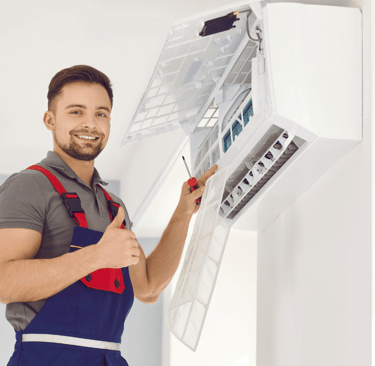 a man in overalls and overalls holding a large air conditioner