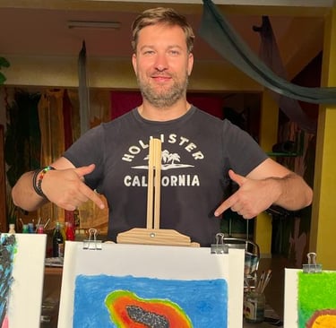 a man standing in front of a display of art work