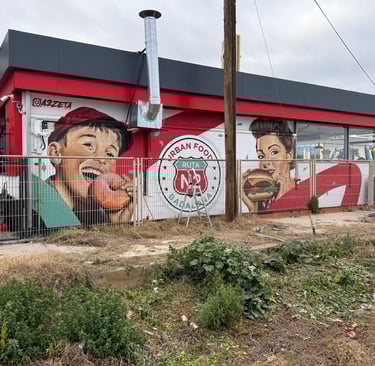 Mural de gran formato sobre fachada urbana realizado con aerosol. Representación figurativa que comb