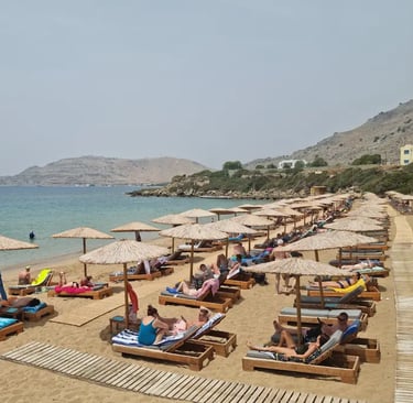 a beach with many people sitting on lounge chairs