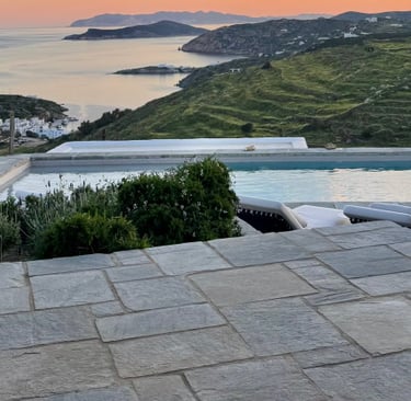 View over the pool onto calm seas and sunset-orange skies