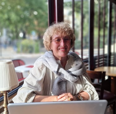 Mireille Bordet dans un café, face à son ordinateur, prête pour un entretien d'échange