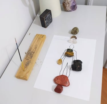 uma fila de cristais de diferentes tipos sobre um desenho de uma pessoa representando os chakaras