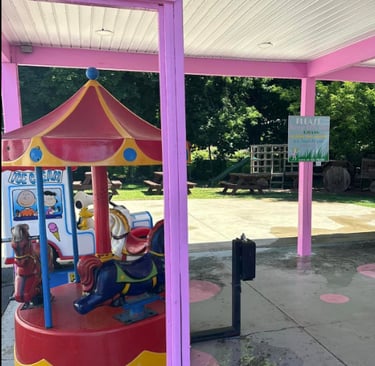 Photo of the merry go round and snoopy ride and time out chair in the back of Chrissy's Cravings