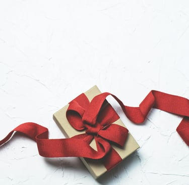a gift box with a red ribbon tied to it