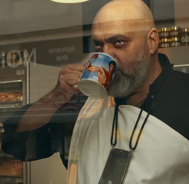 un homme en tenue de boucher tient un mug sur lequel on peut voir Sylvester Stallone en Rocky