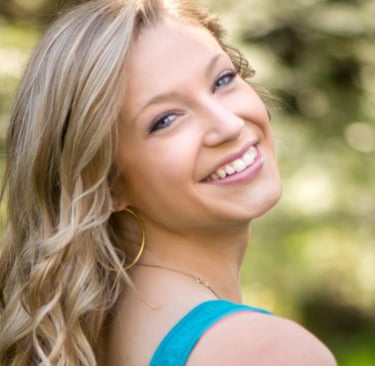 a woman in blue smiling and looking at the camera