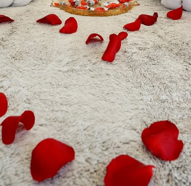 The photo shows a bed decorated for a honeymoon special in the BDSM Love Apartment with champagne and rose petals. 