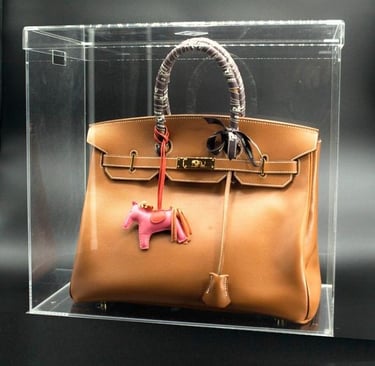 Brown luxury bag in a transparent acrylic case.