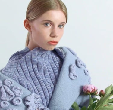une jeune femme avec une tenue de créateur bleue portant un bouquet de roses, représentant la mode