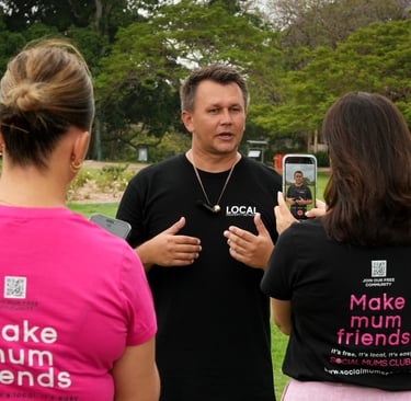 Local business owner speaking on camera while being filmed for social-first content outdoors