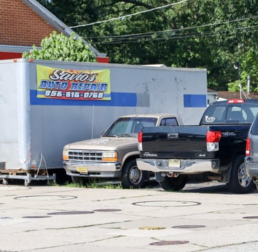 Old banner of Savio's auto repair on a trailer