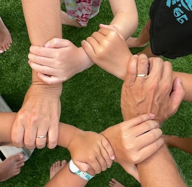 a group of people holding hands together in a circle