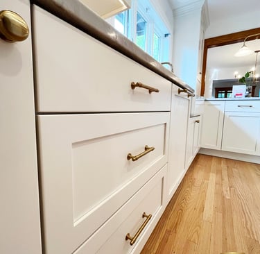 a kitchen with white cabinets and a wooden floor