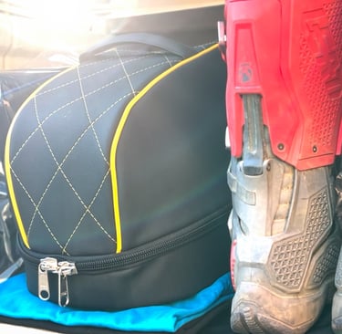 a pair of mx boots and a luxury helmet bag