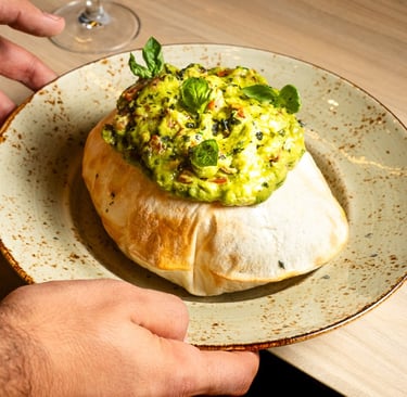 a person holding a plate with a bowl of food