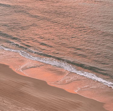 un atardecer rosado reflejado sobre el agua del mar