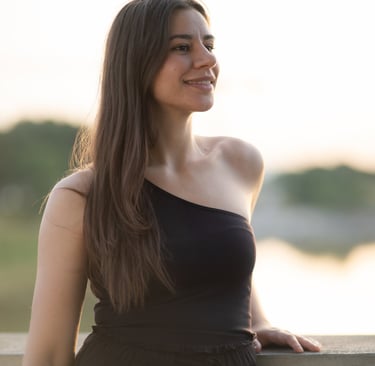 a woman in a black dress standing on a ledge
