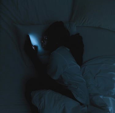 a person laying in bed with a cell phone